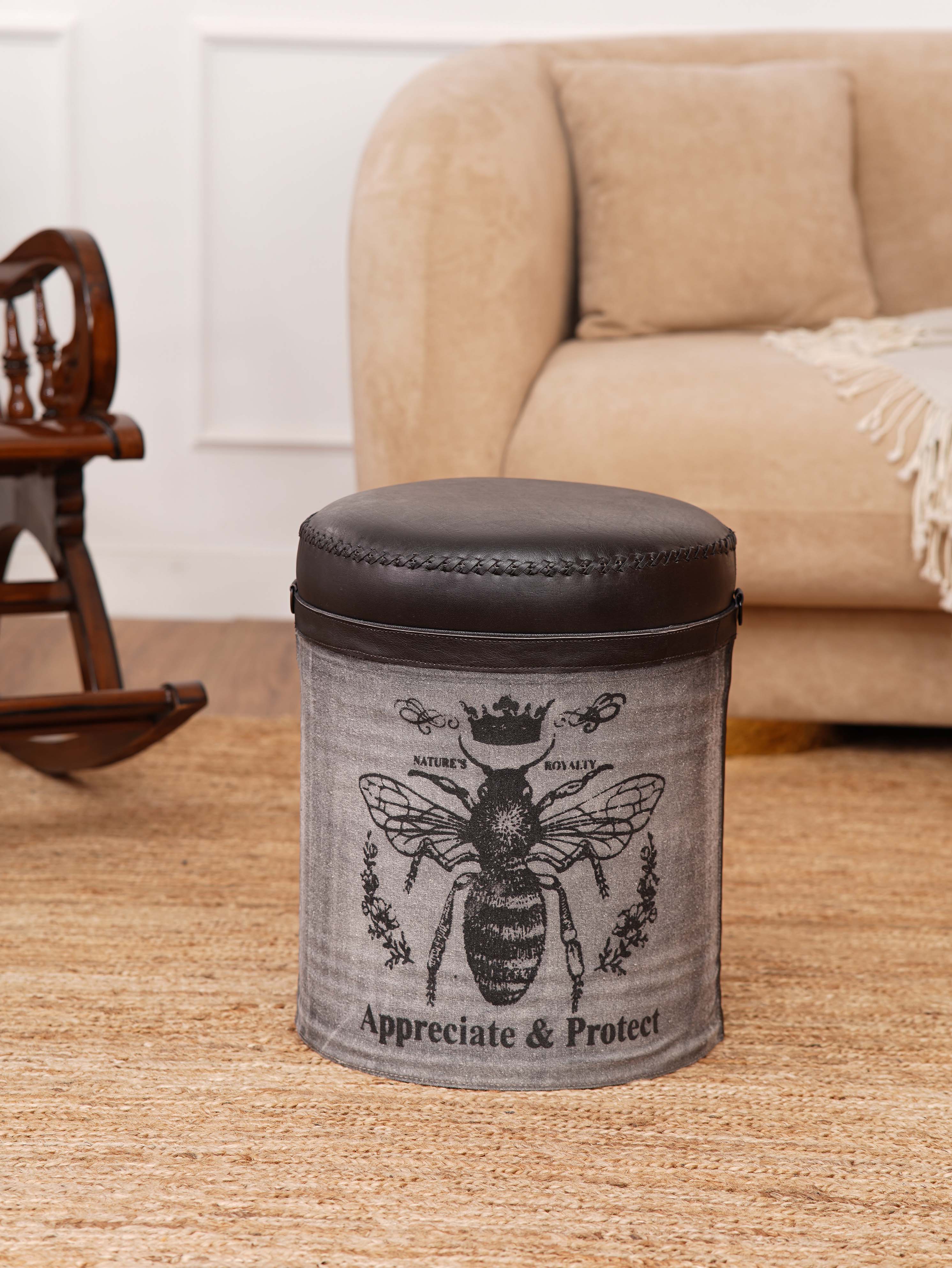 Round printed ottoman with leather top and bee design in modern room