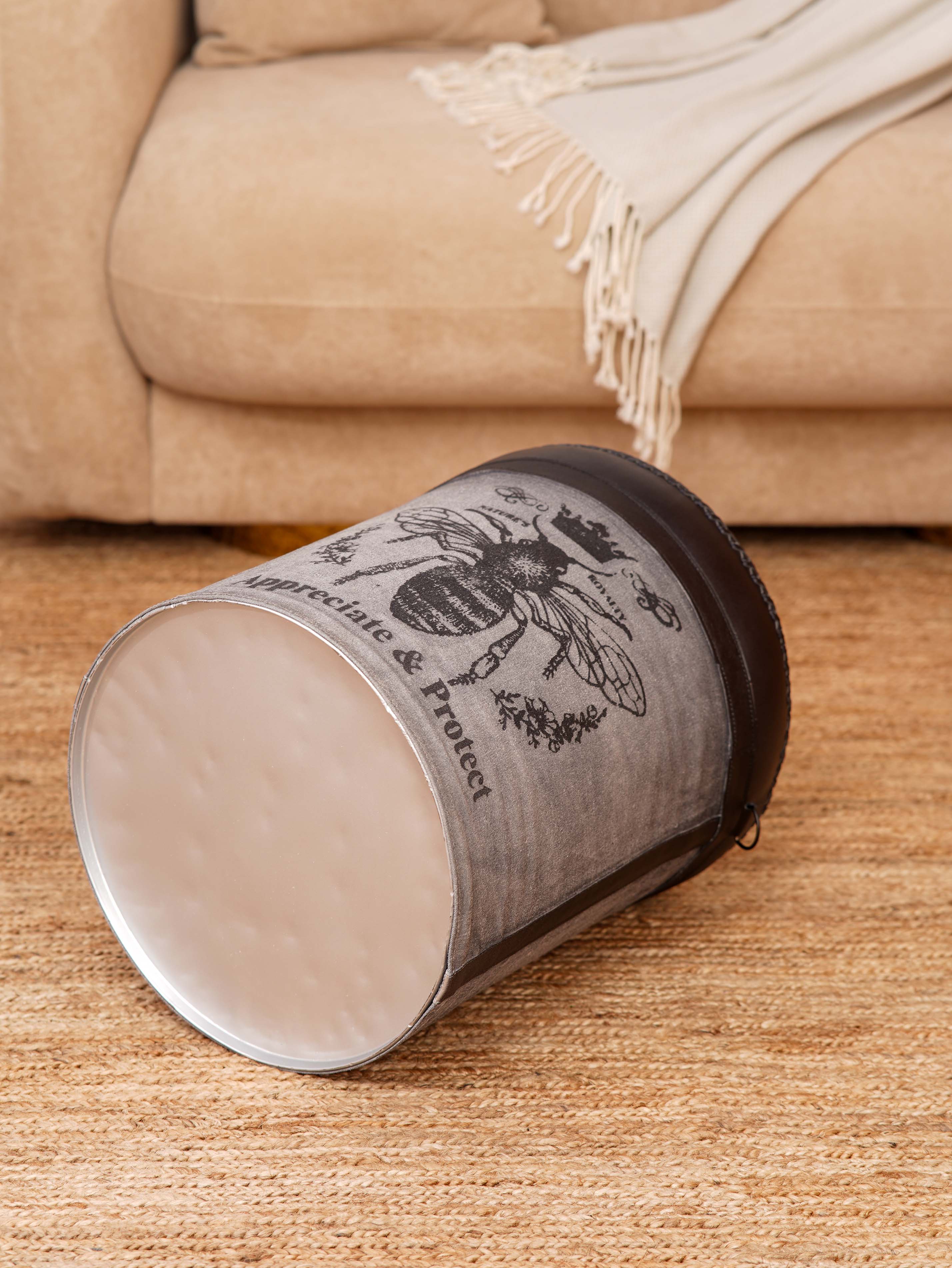 Upcycled tin base ottoman with mixed-material upholstery and stitched handles