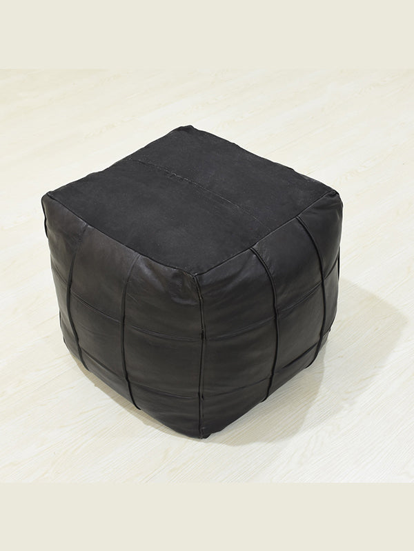 Overhead view of filled square black leather ottoman upside down.