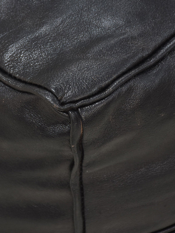 Detail of full grain leather and artisan stitching on black pouf