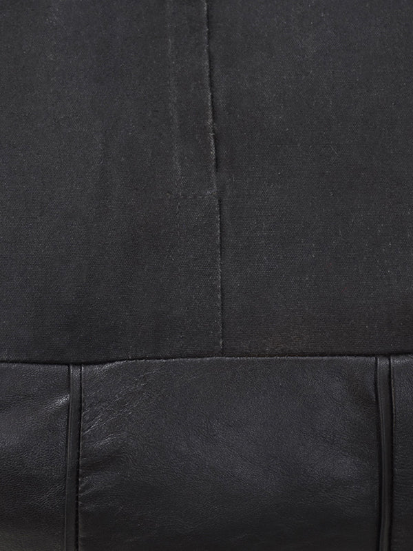 Detail of full grain leather and artisan stitching on black pouf