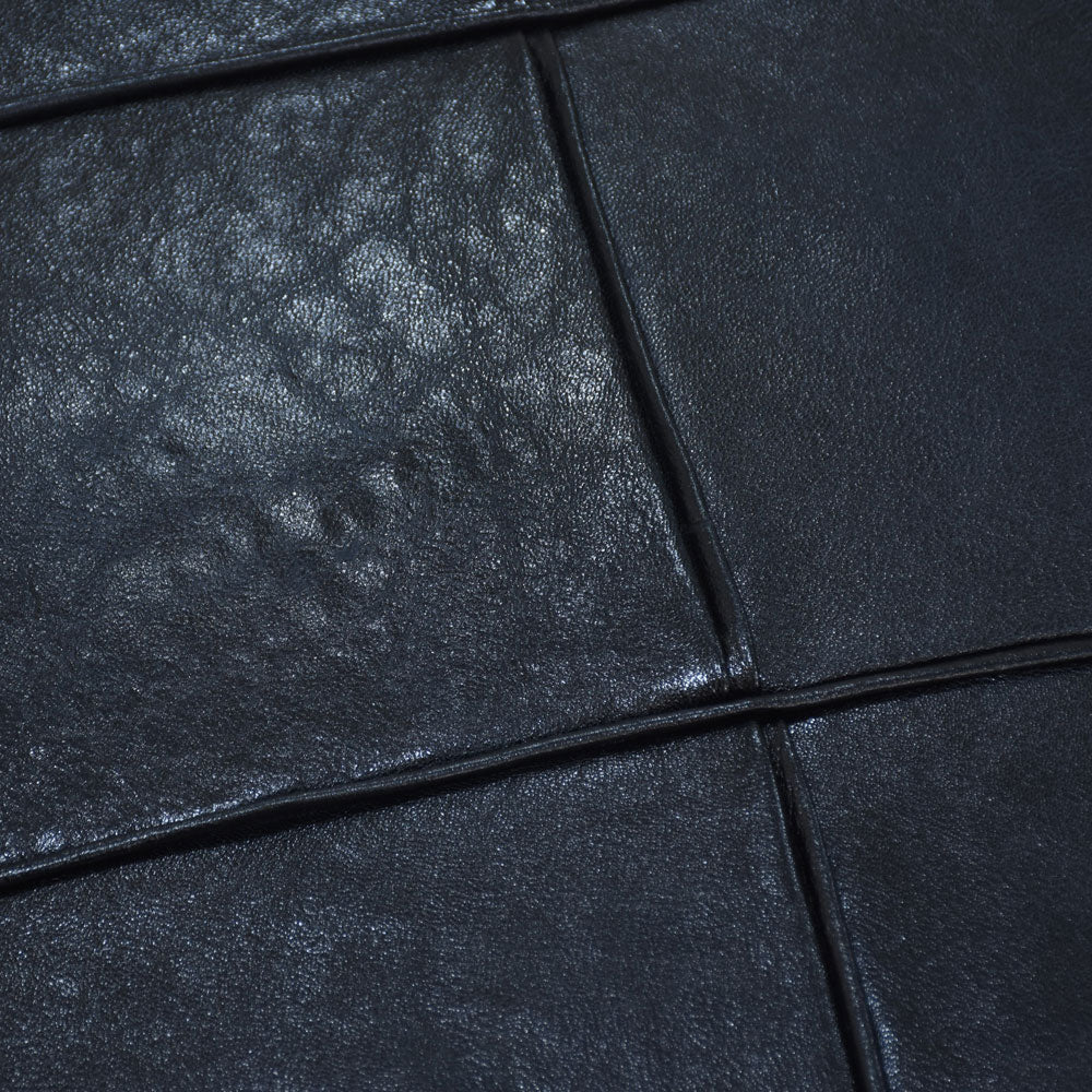 Detail of full grain leather and artisan stitching on black pouf