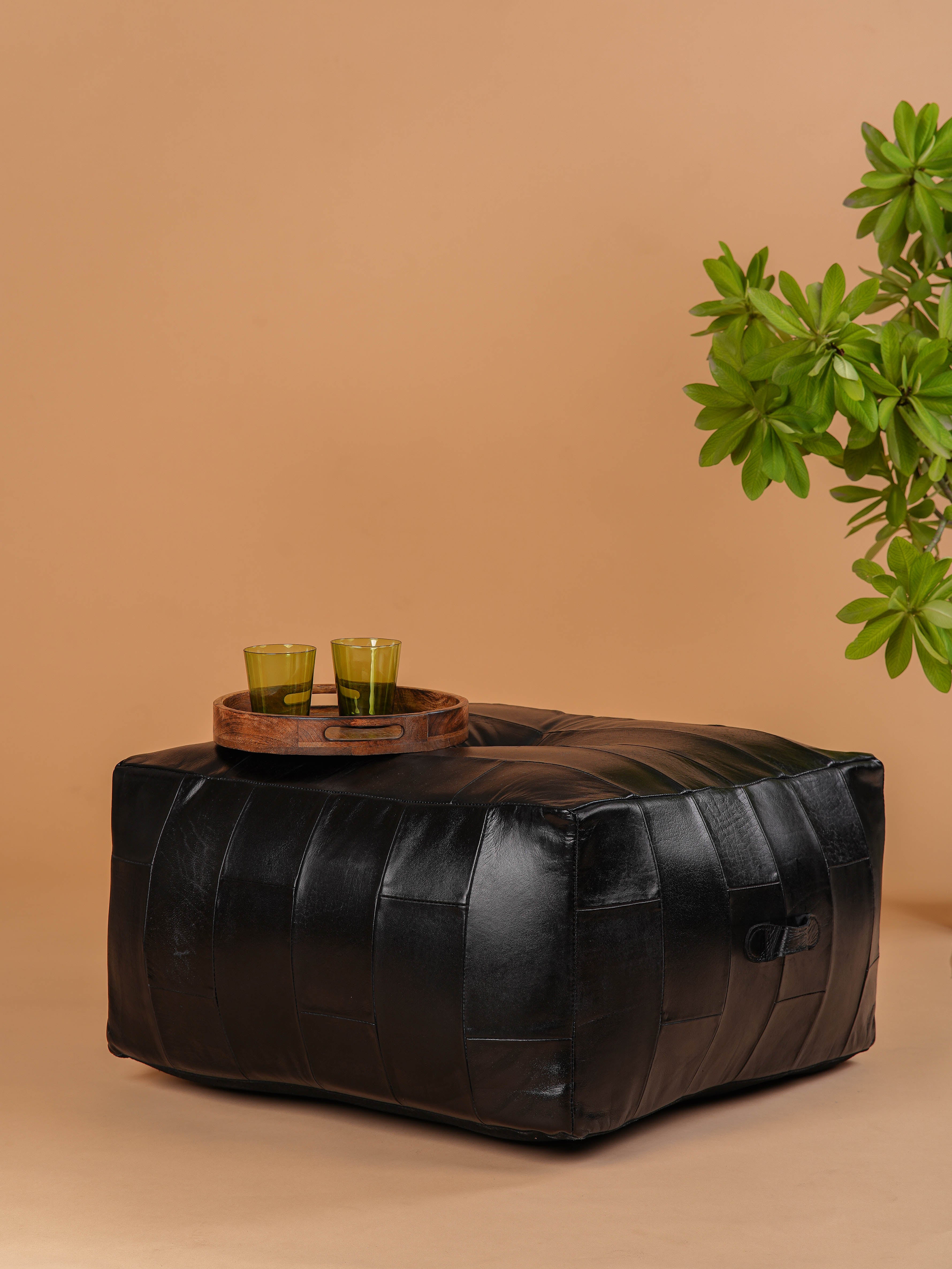 Low-profile square pouf in black buffalo leather styled as coffee table