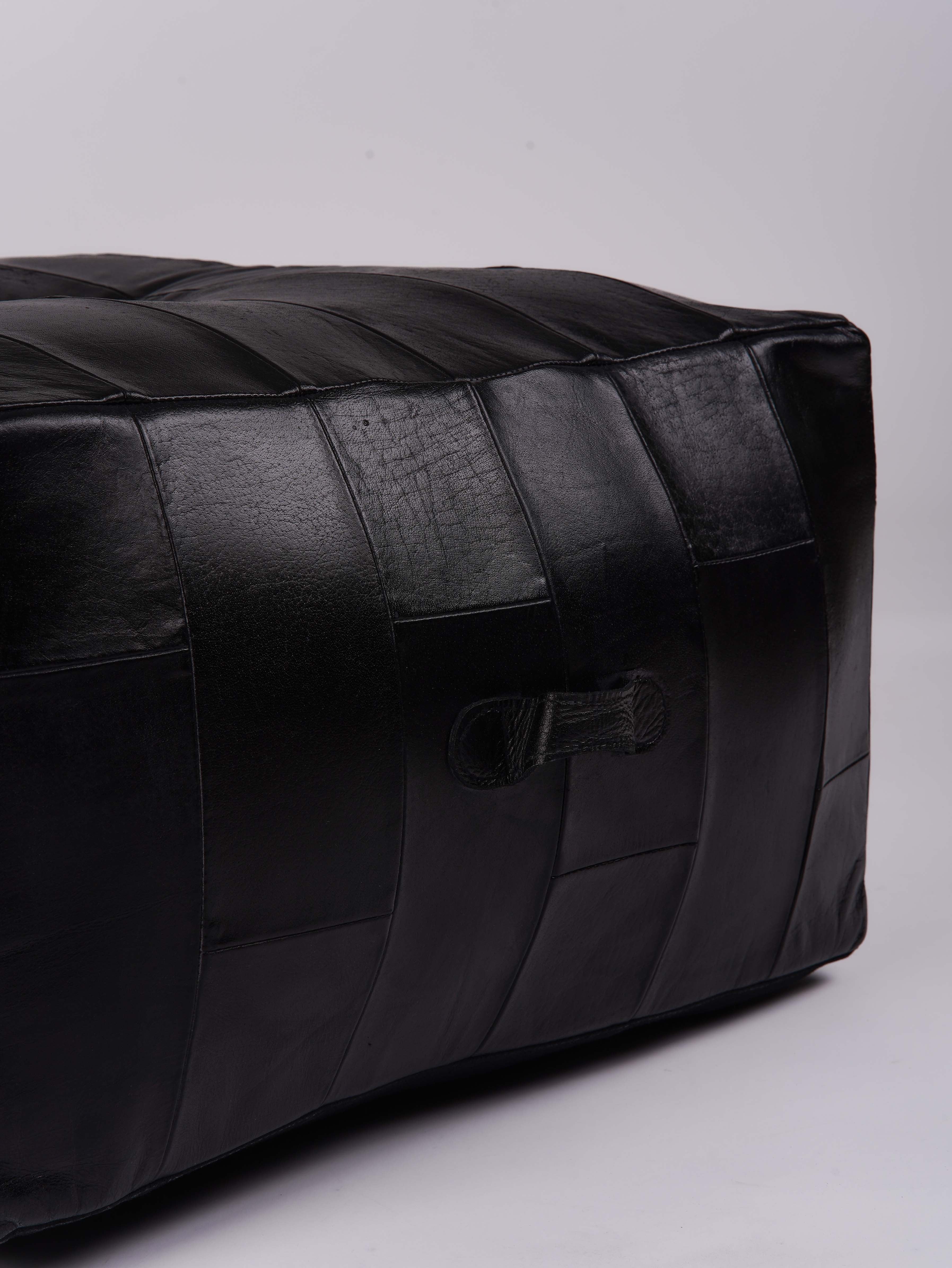 Sleek stitched leather ottoman with vertical panel design