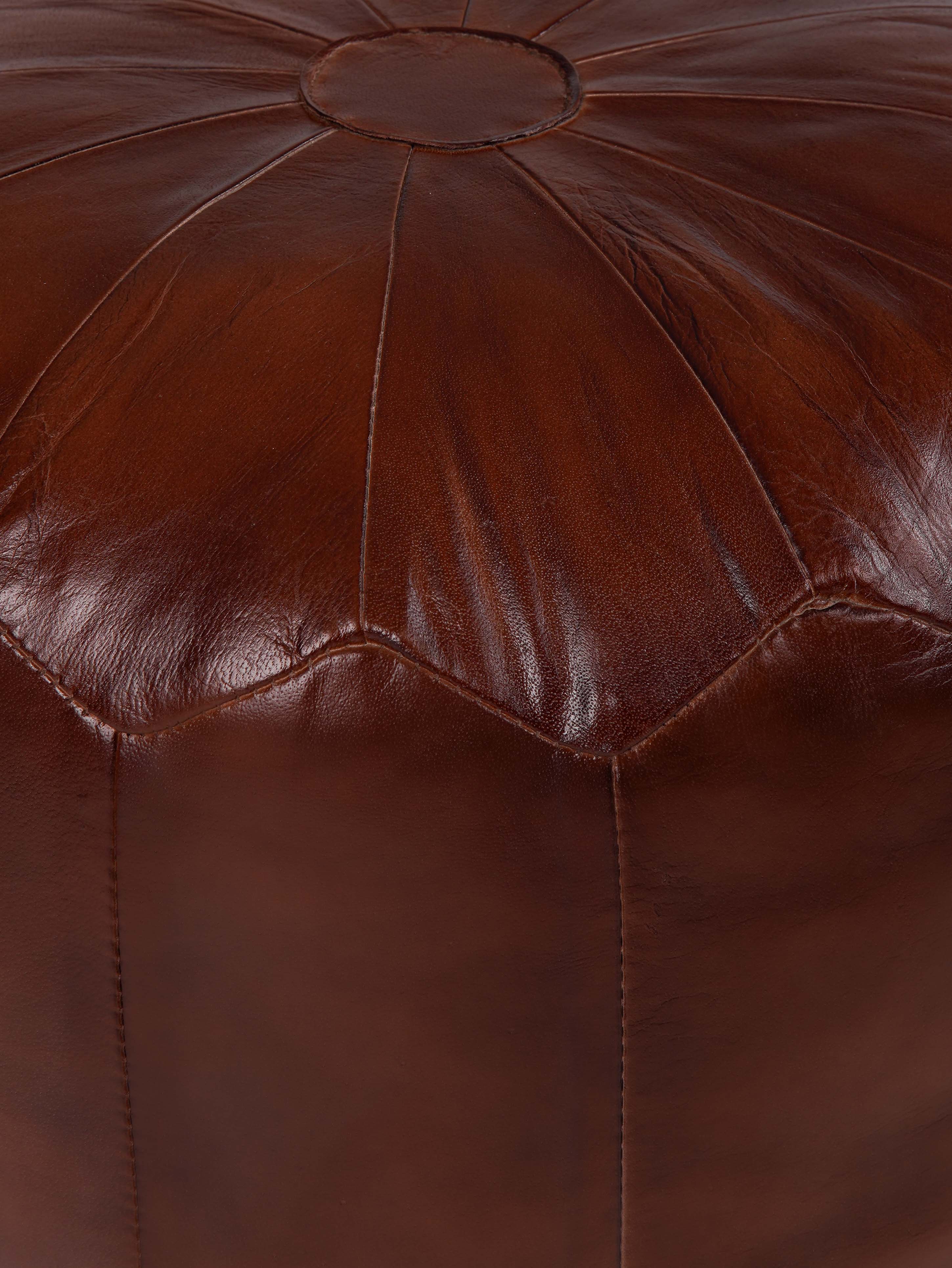 Structured leather pouf with panel stitching detail and warm brown tone