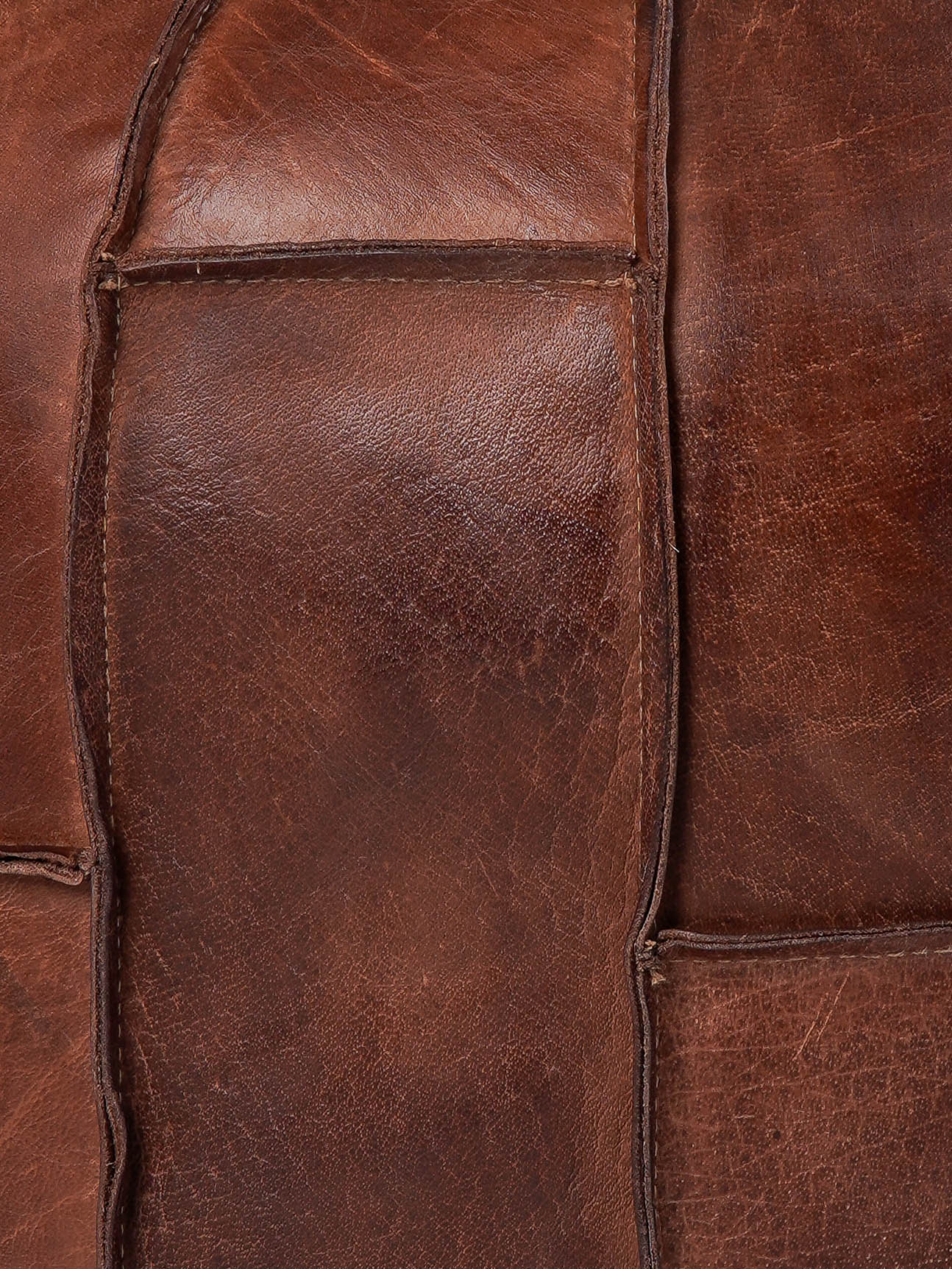 Detail of prairie-style stitching on black buffalo leather pouf