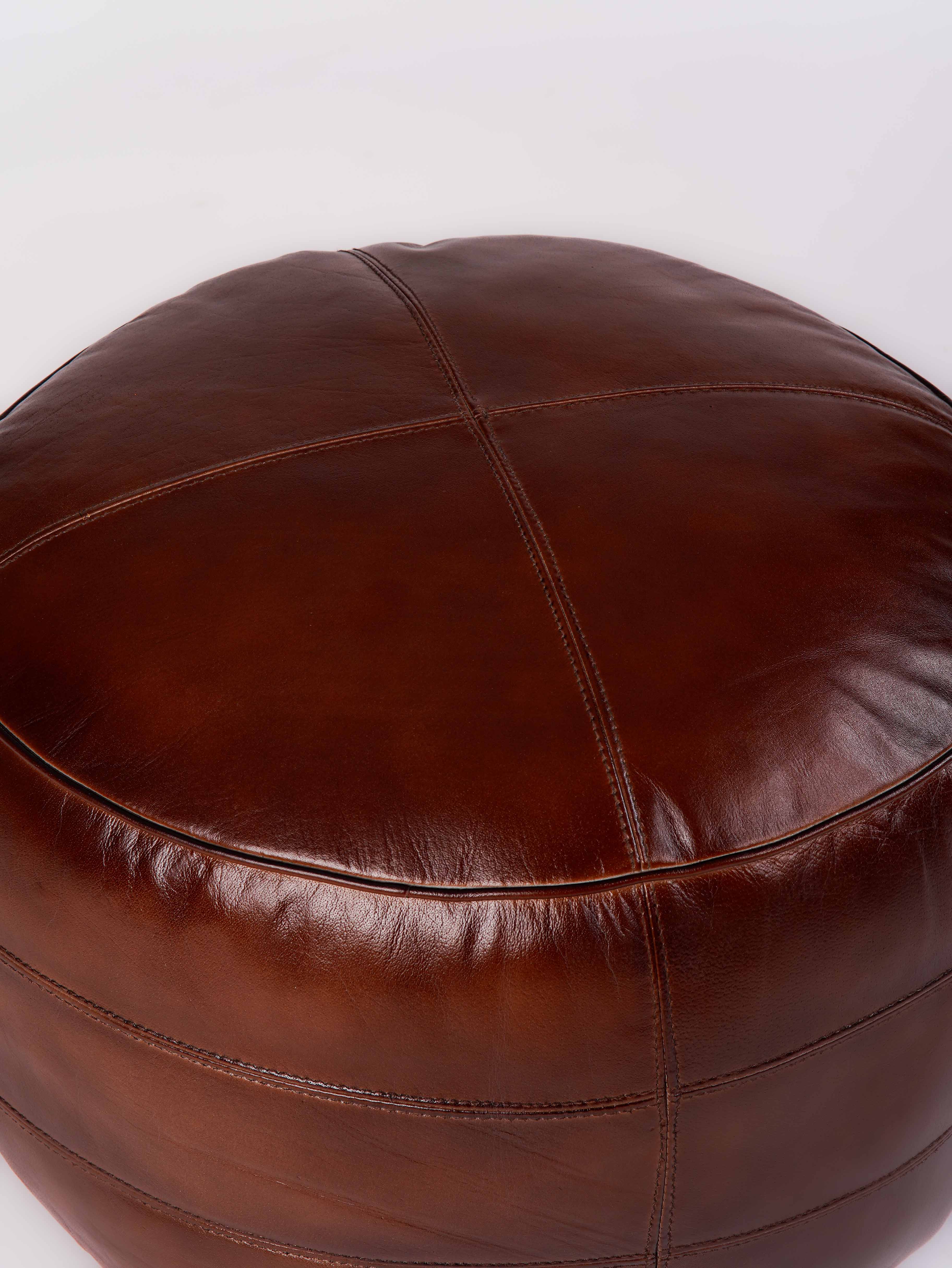 Top-down view of artisan-crafted leather pouf with center stitching
