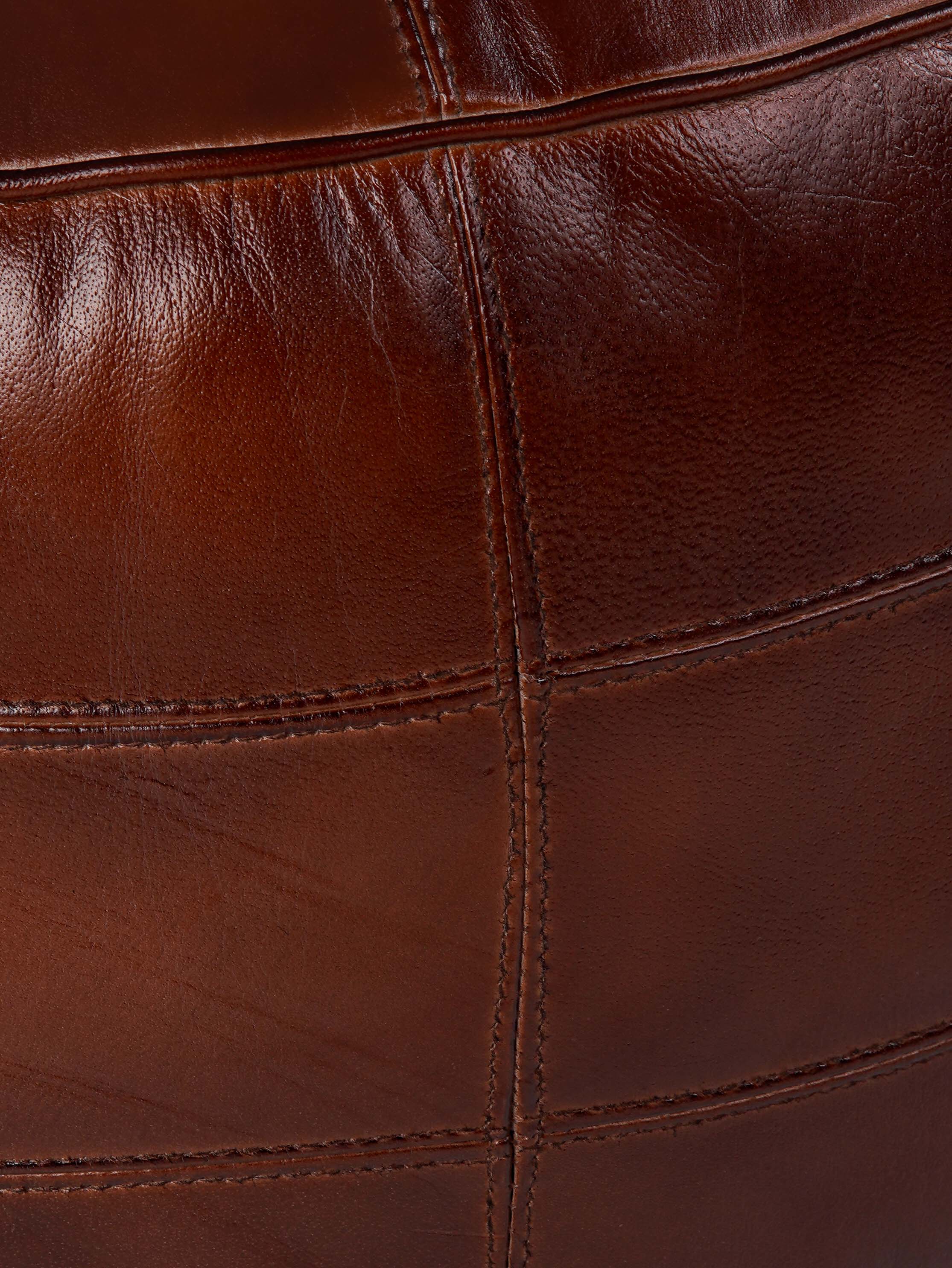 Stitched leather panels on brown buffalo pouf with full grain texture