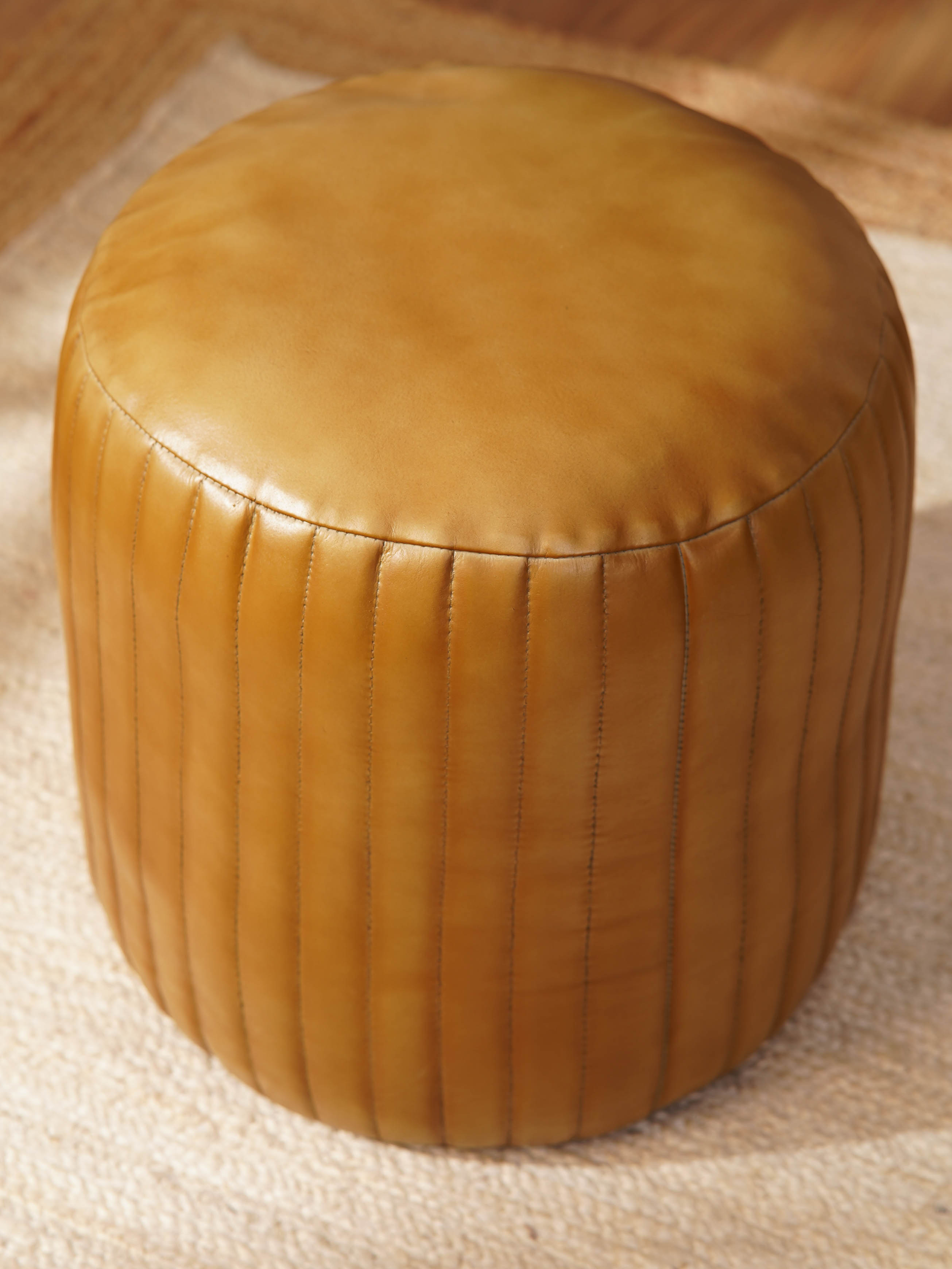 Top-down view of filled handmade pouf in beige buffalo leather
