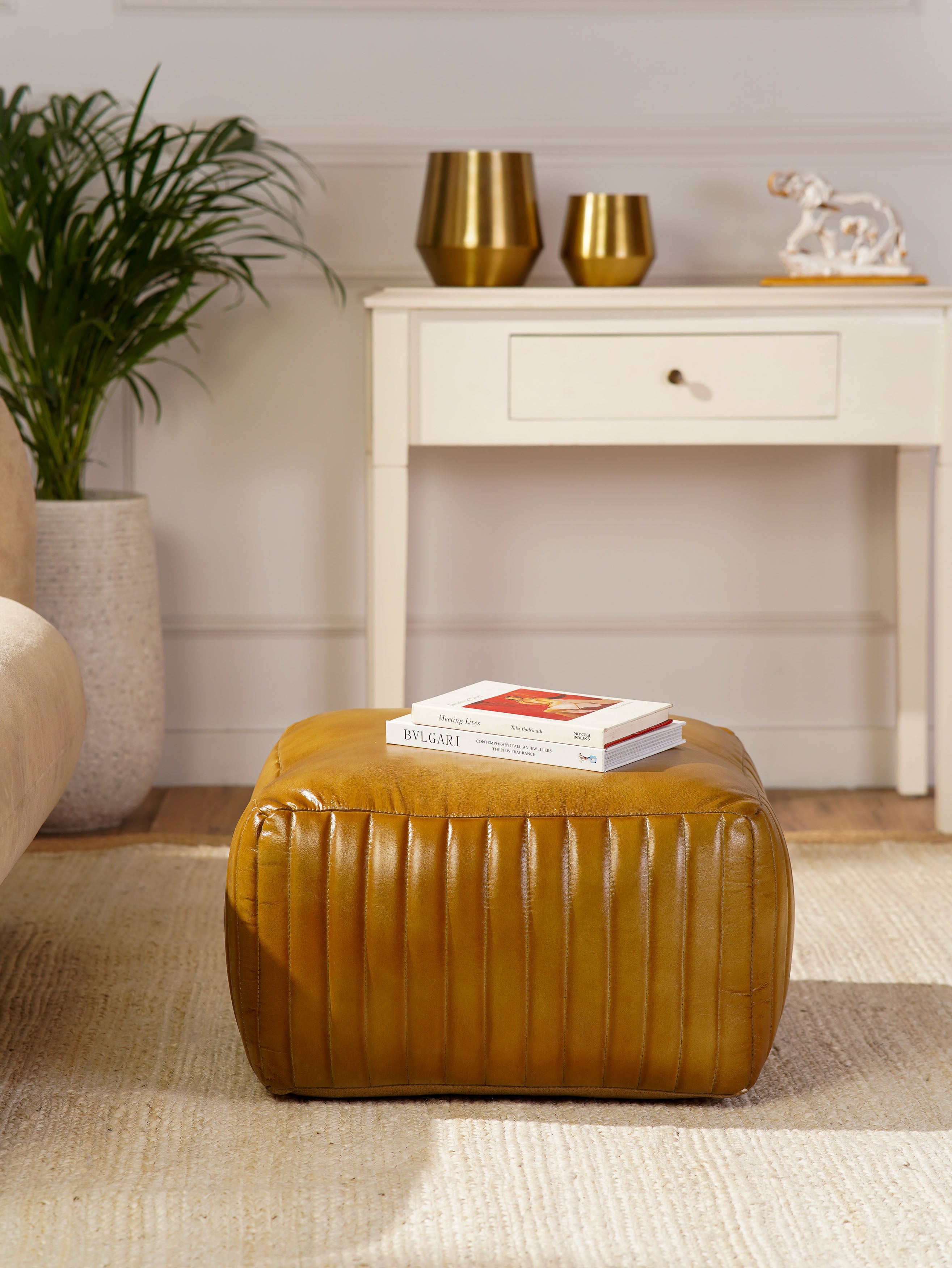 Sandstone pouf as accent piece in cozy living room with neutral tones