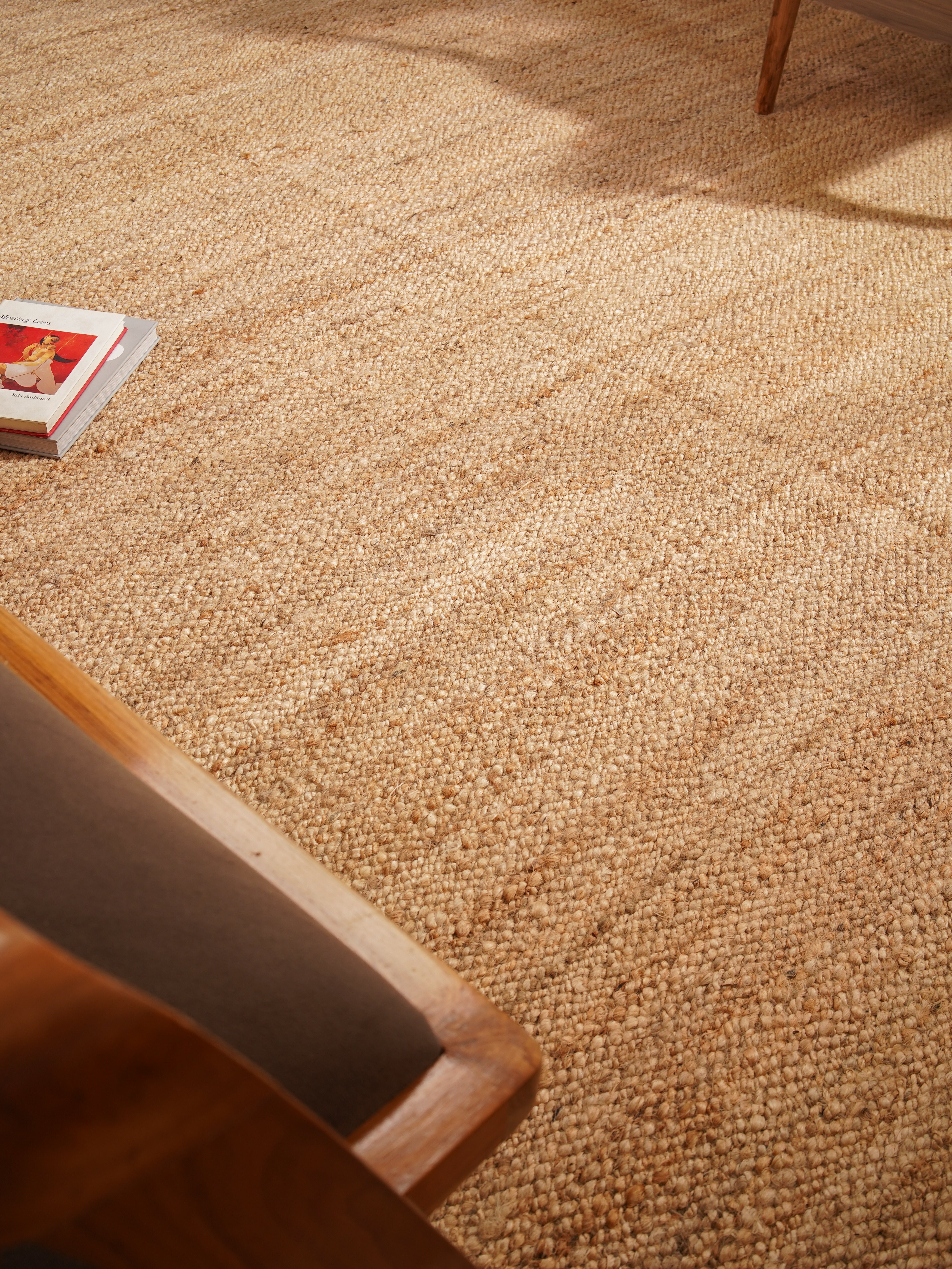 Light brown jute rug styled in neutral modern interior