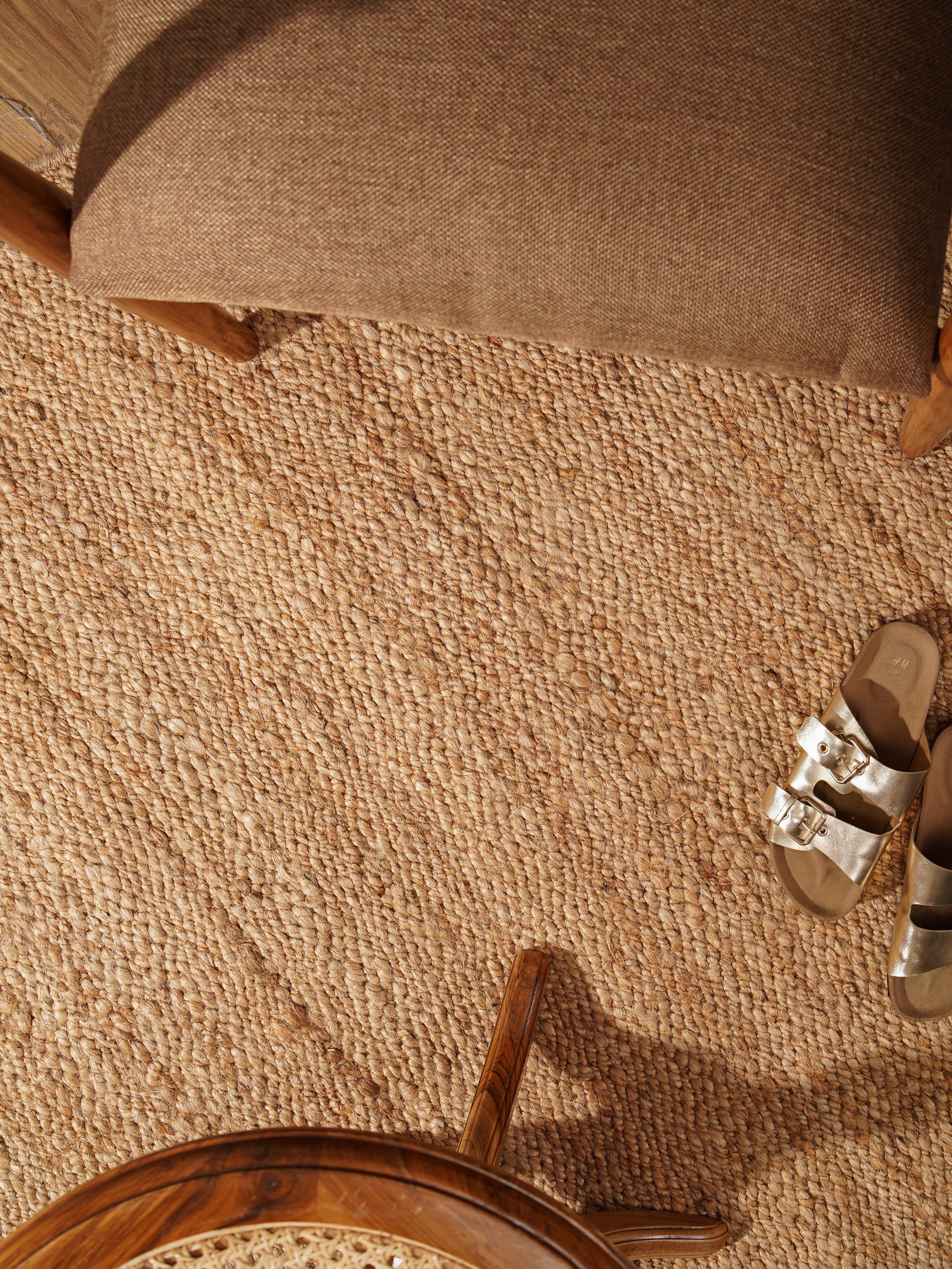 Top view of light brown handwoven jute rug under coffee table