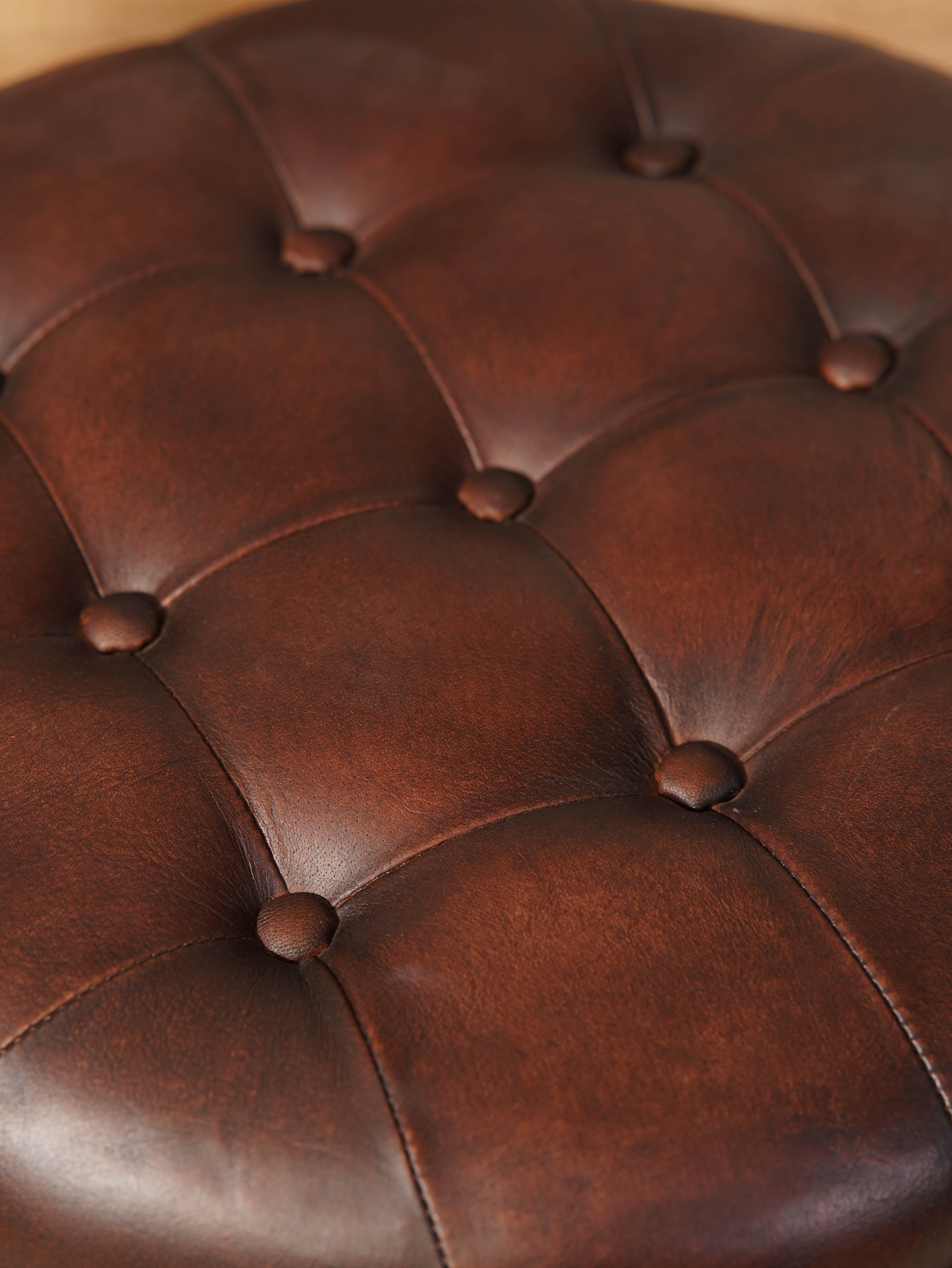 The Regal Repose – Round Tufted Leather Ottoman with Solid Wood Frame