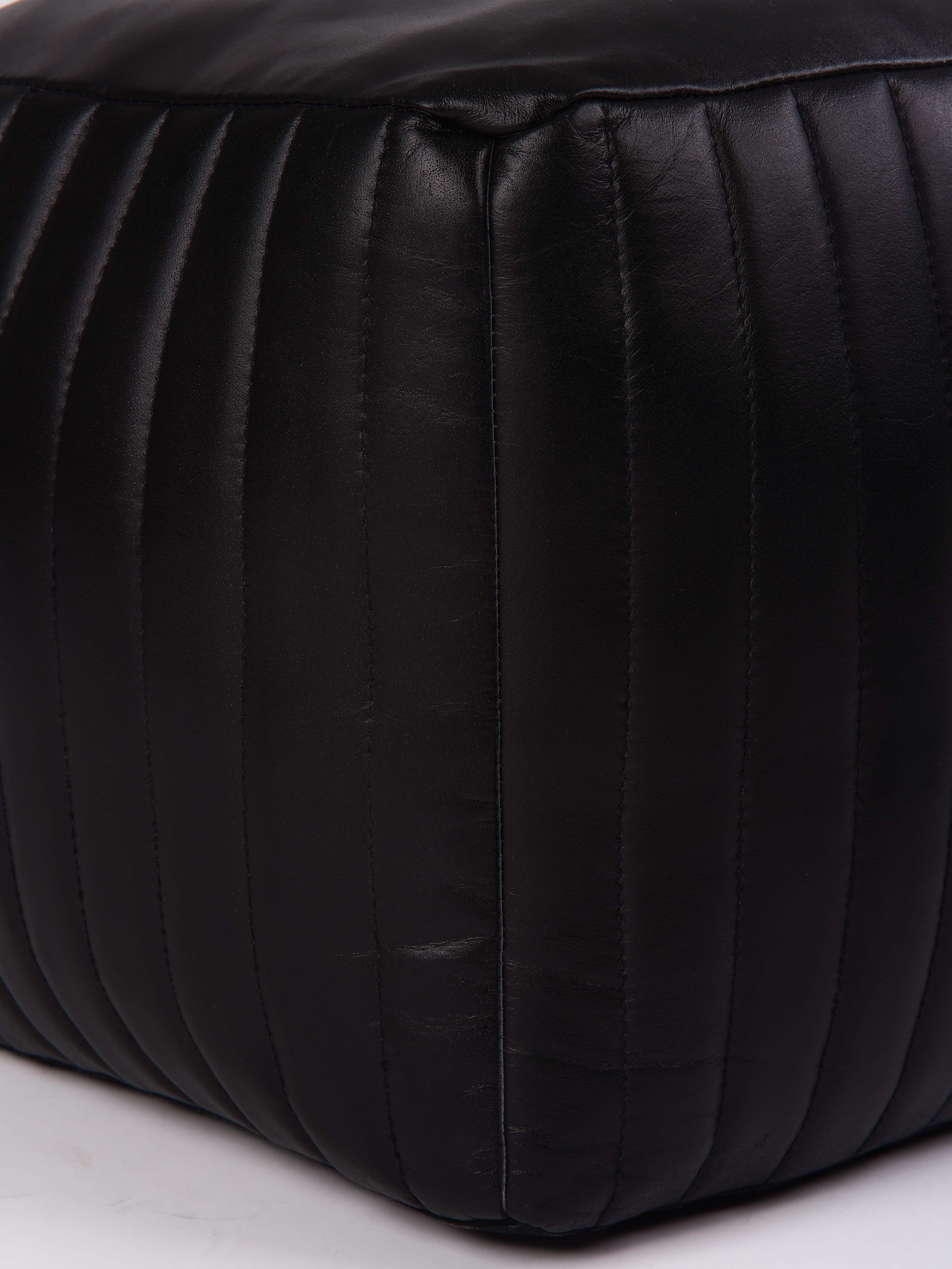 Detail shot of stitching and leather texture on square pouf
